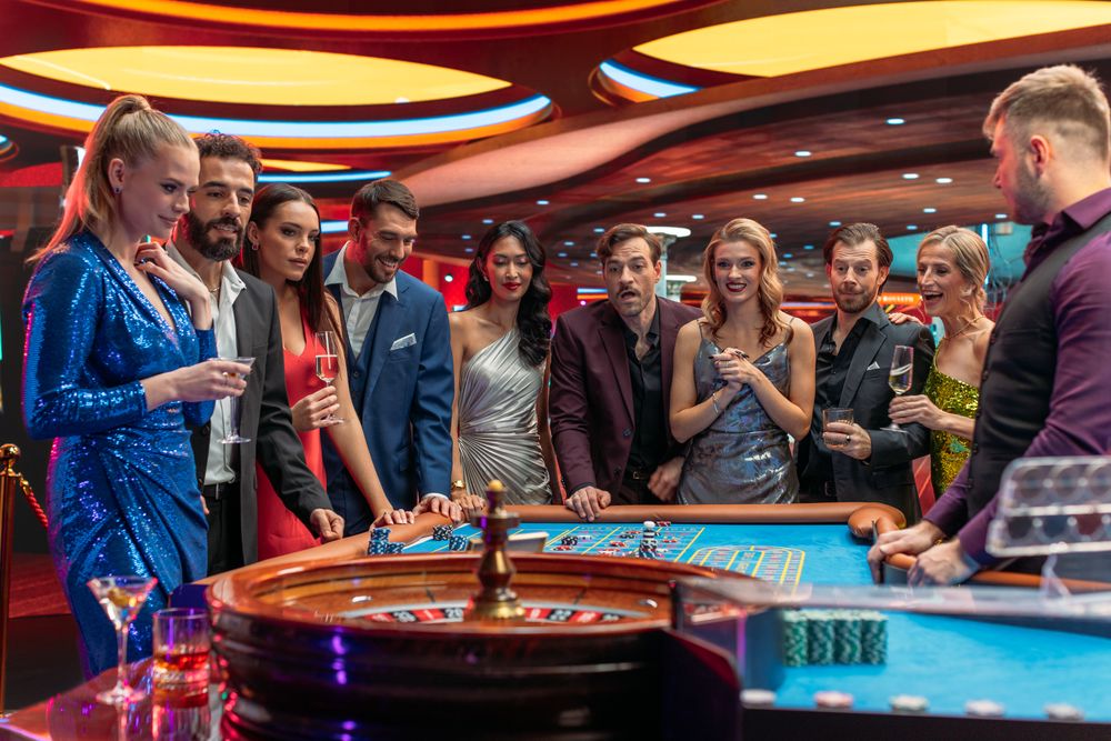 Multiethnic Young Adults Playing an Engaging Game of Roulette, Spending a Fun Evening in a Fancy Hotel Casino