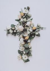 Easter layout with flowers and leaves in cross shape on light paper background