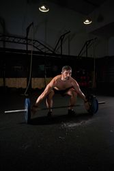 Strong concentrated man training with barbell