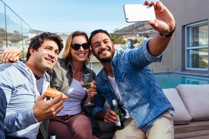 Young friends taking selfie on a rooftop party