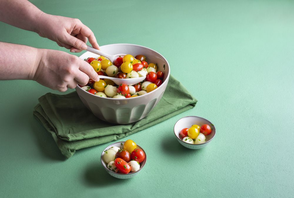 Melon caprese salad being mixed