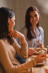 Pregnant woman and friend talking while eating dessert