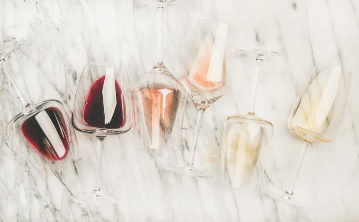 Glasses of wine laying on marble background