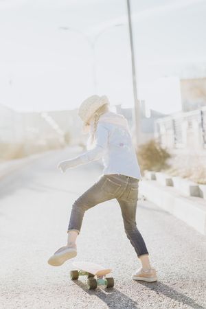 Stylish girl with skateboard on street
