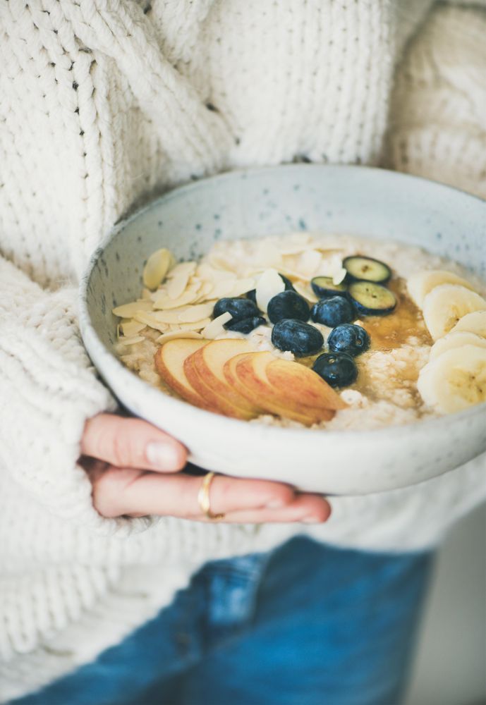 Close up of organic oatmeal with fruits, nuts, and honey