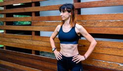 Cheerful female athlete in front of a wooden background