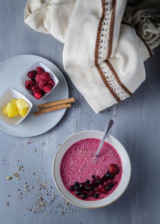 Smoothie bowl with fresh berries and sesame served on table