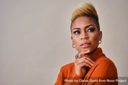 Studio shot of Black woman with her hand to her chin with short blonde hair bxgpn4
