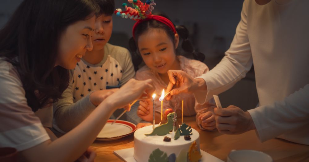 Family Memories: Portrait of Cute Little Girl Making a Wish Before Blowing Out her Birthday Cake Candles.