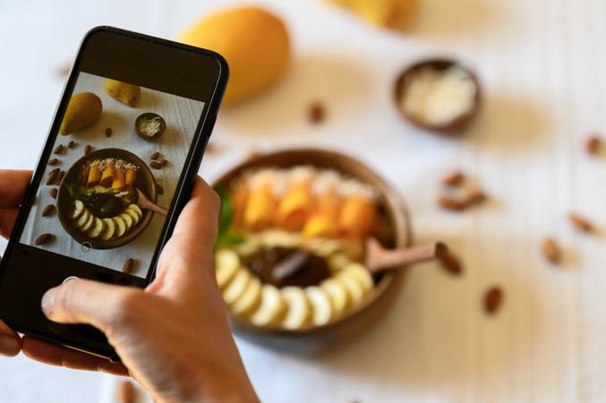 Crop person taking photo of healthy breakfast