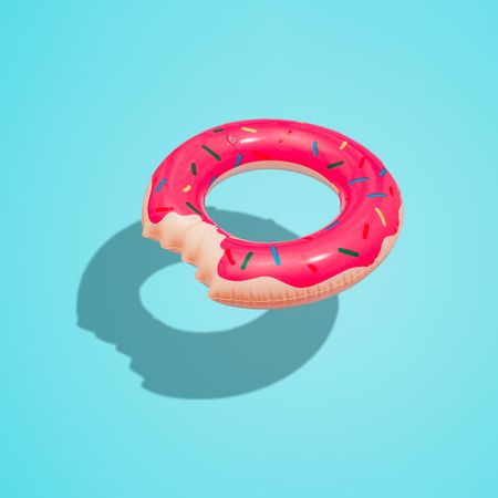 Donut inflatable toy with bright blue background and sun shadow