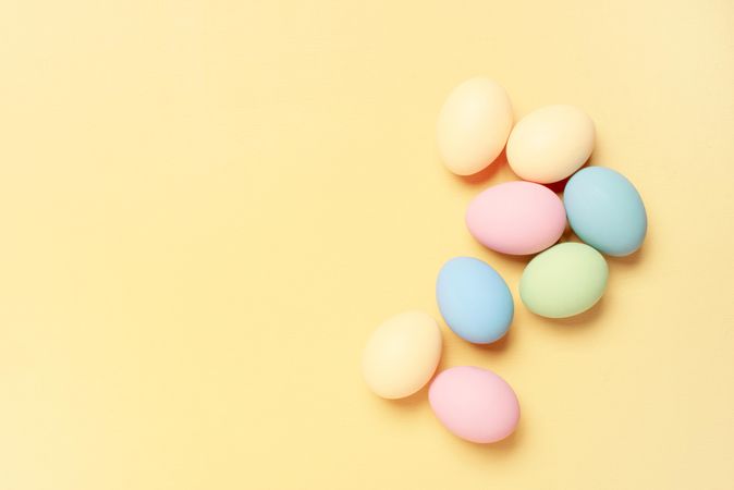 Colorful eggs on yellow background with copy space