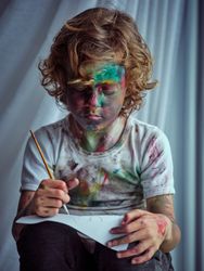 Little artist looking at paper and engrossed in painting