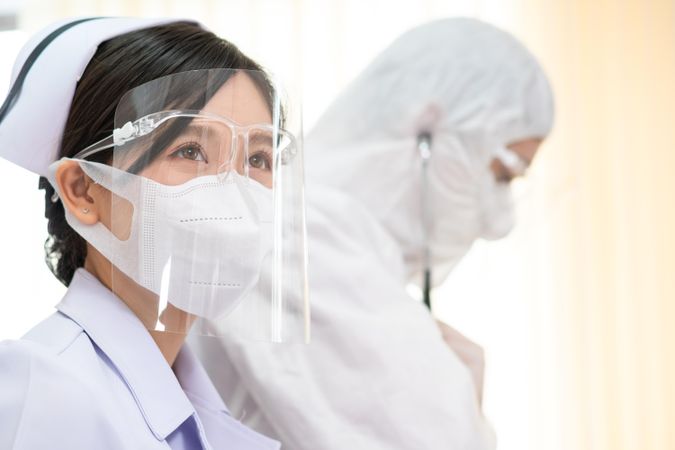 Asian nurse in protective mask and face shield in hospital