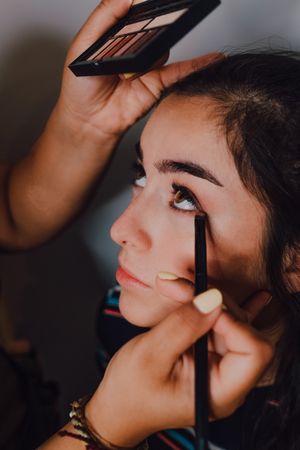 young female getting makeup in salon