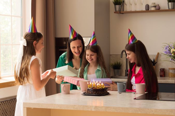 Happy family moment as young girl opens birthday presents