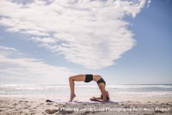 Flexible woman doing back bend at the beach bGlrV0