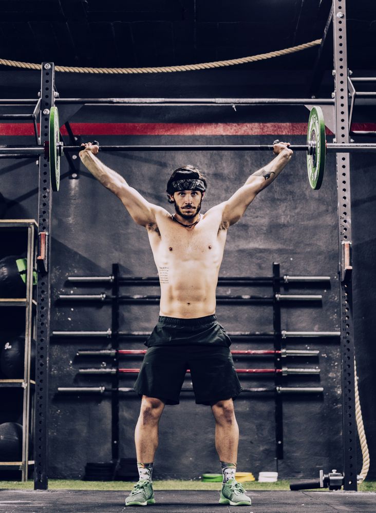 strong and athletic man doing barbell workout in modern gym