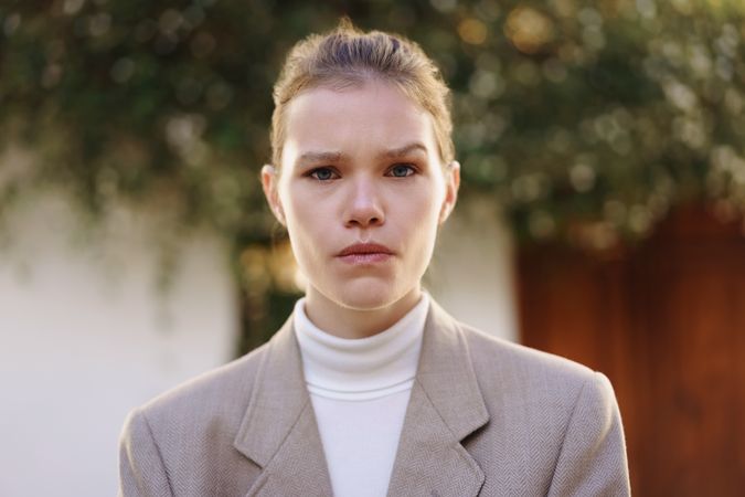 A Confident Young Woman Dressed in Stylish Business Attire Poses Outdoors to Impress