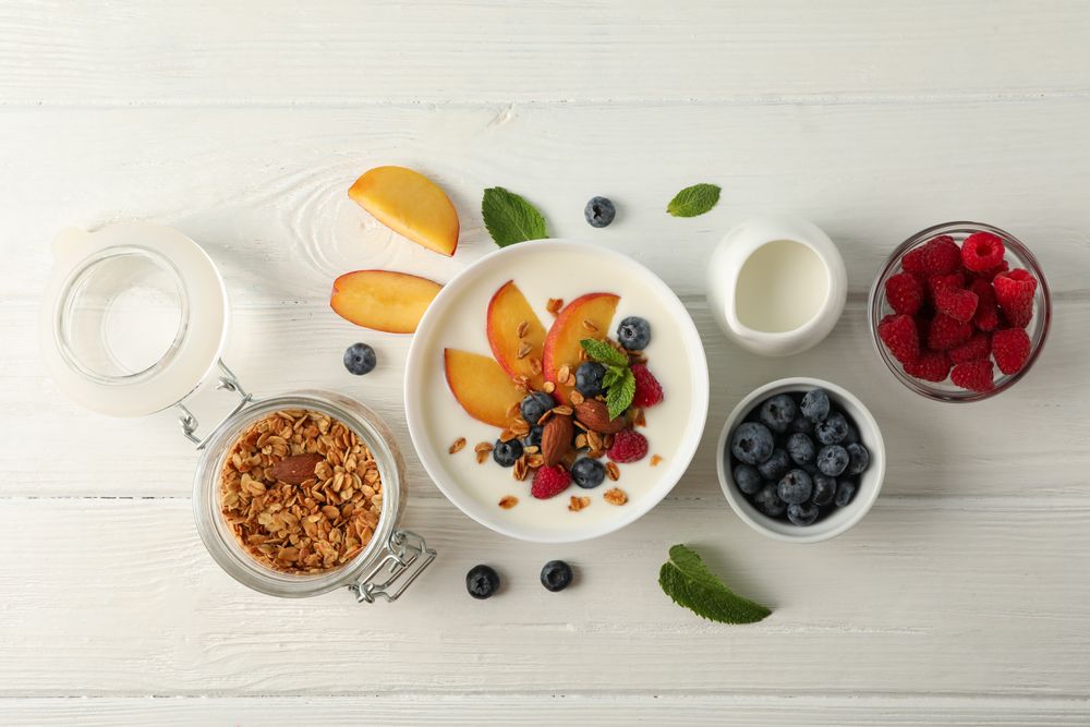 Flat lay composition with parfaits dessert and ingredients on wooden background