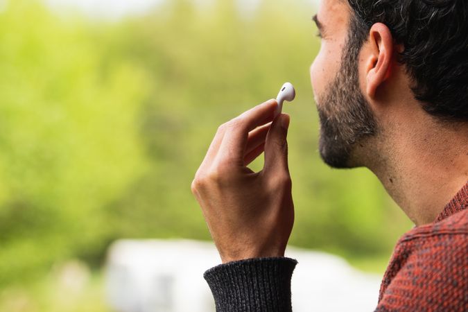 Anonymous man with earbuds against green background