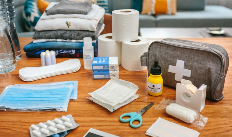 Emergency backpack equipment with first aid kit organized on the table