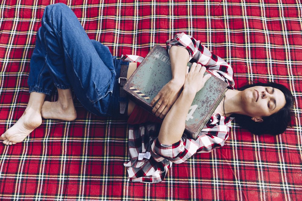 Cheerful woman with old case on picnic