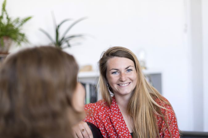 Two women friends chatting on the couch at home