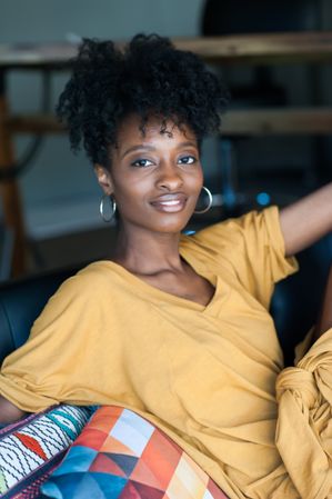 Portrait of beautiful Black woman with curly bun smiling and looking at camera