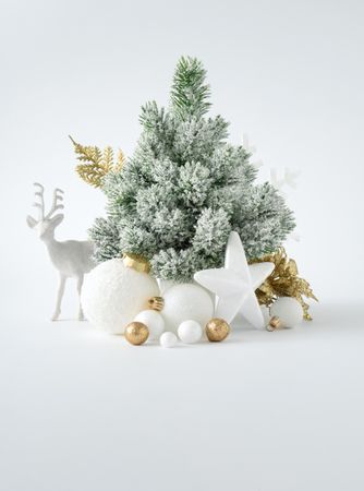 Snowy Christmas tree with  decorations on light background