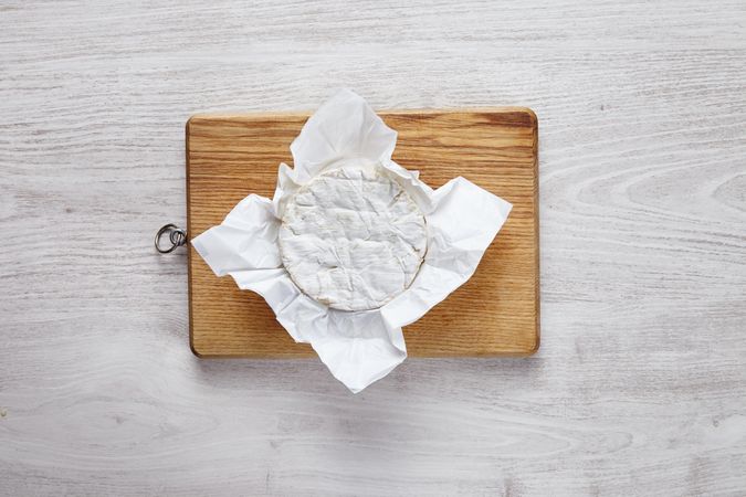 Wheel of brie cheese on wooden board