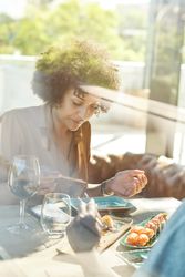 Woman eating sushi in restaurant