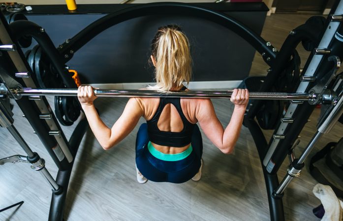 Woman lifting barbell in gym