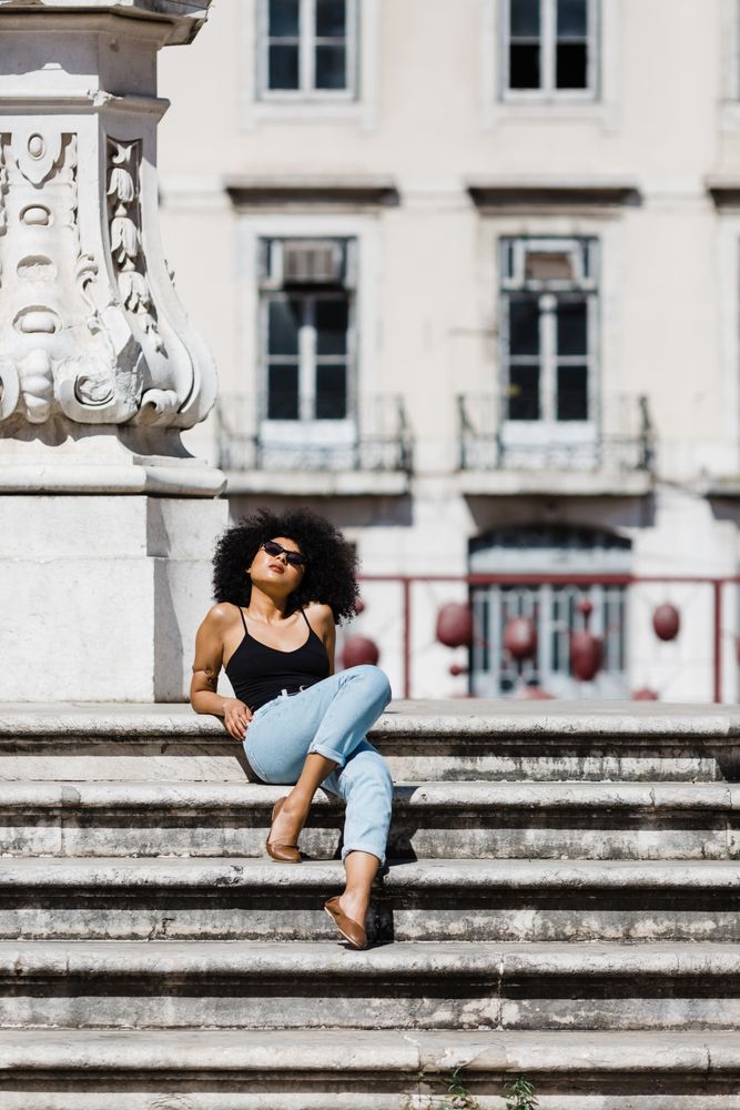 Black female sitting on stairs outdoors