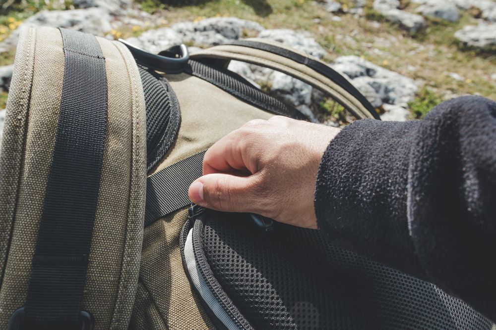 Man closing pocket of backpack