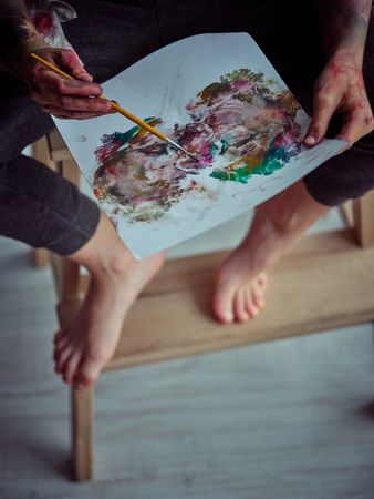 Faceless kid painting on paper