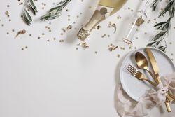 Happy New Year decorative border with champagne, branches, confetti and table setting
