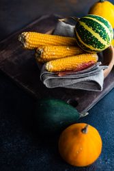 Corn and mini squashed in rustic table setting