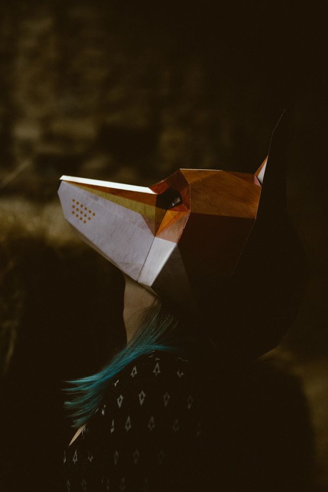 Woman in red fox mask walking in forest