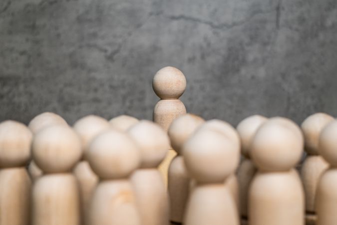 wooden figure stand on podium speech to the wooden group crowd. leadership and teamwork concept