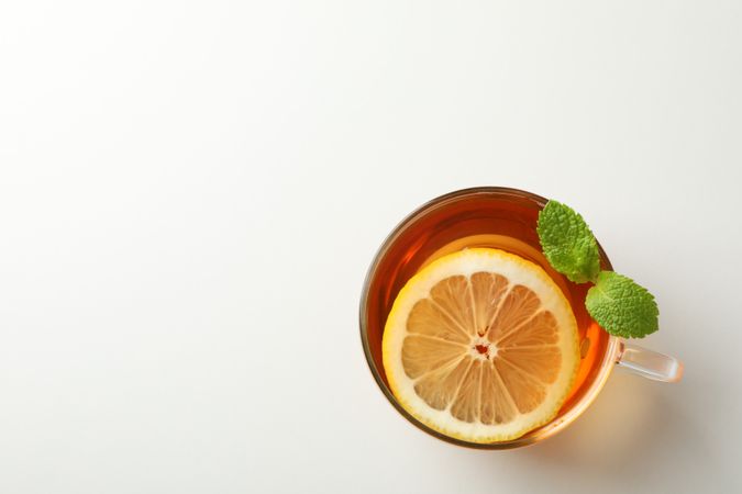 Cup of tea, mint and lemon on blank background, top view