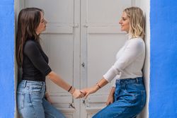 Positive women holding hands in doorway