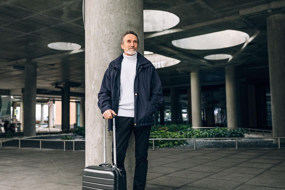 Stylish mature tourist standing outdoors waiting on taxi