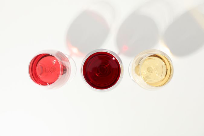 Flat lay composition. Glasses with different wine on blank background, top view