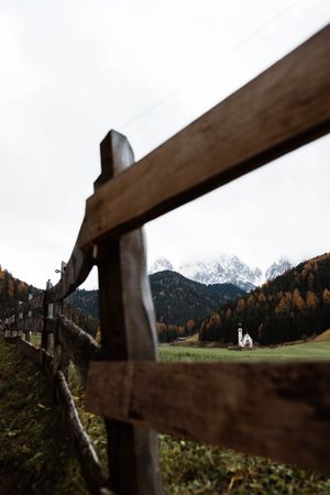 Small church on cliff near forest and mountains