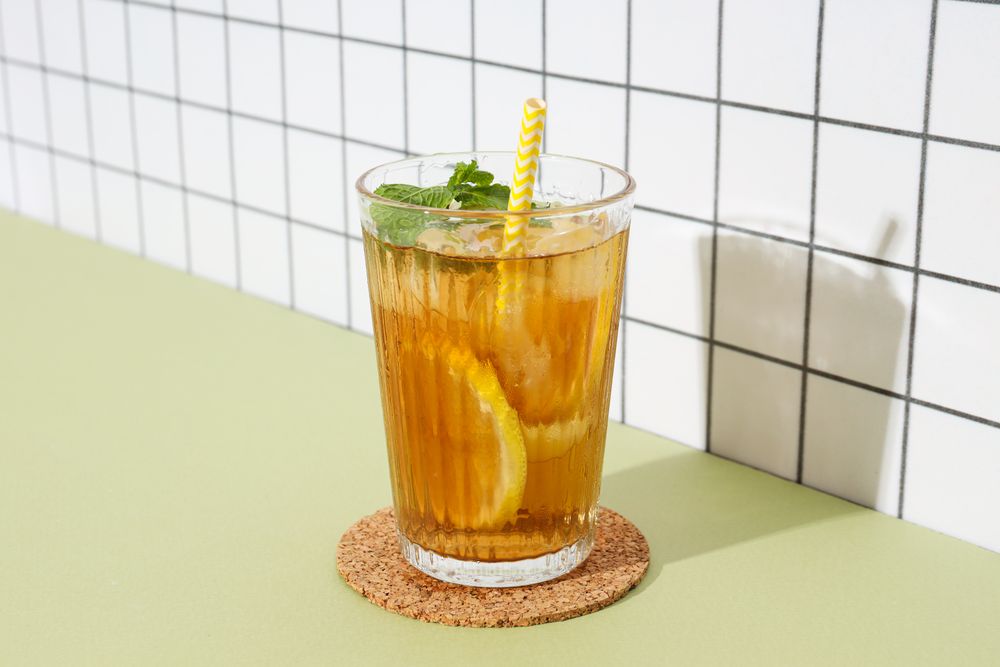 A glass of delicious cold tea on a plain background