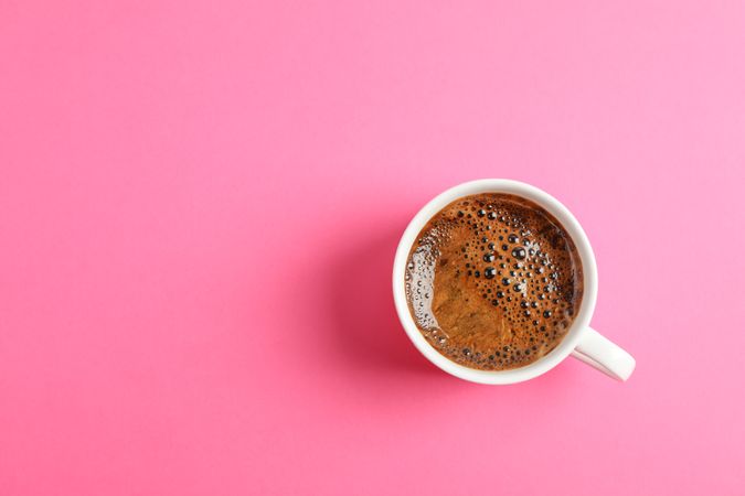 Cup of coffee on color background, space for text