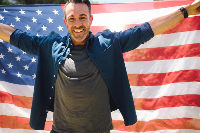 Man celebrating an occasion carrying the American flag behind him