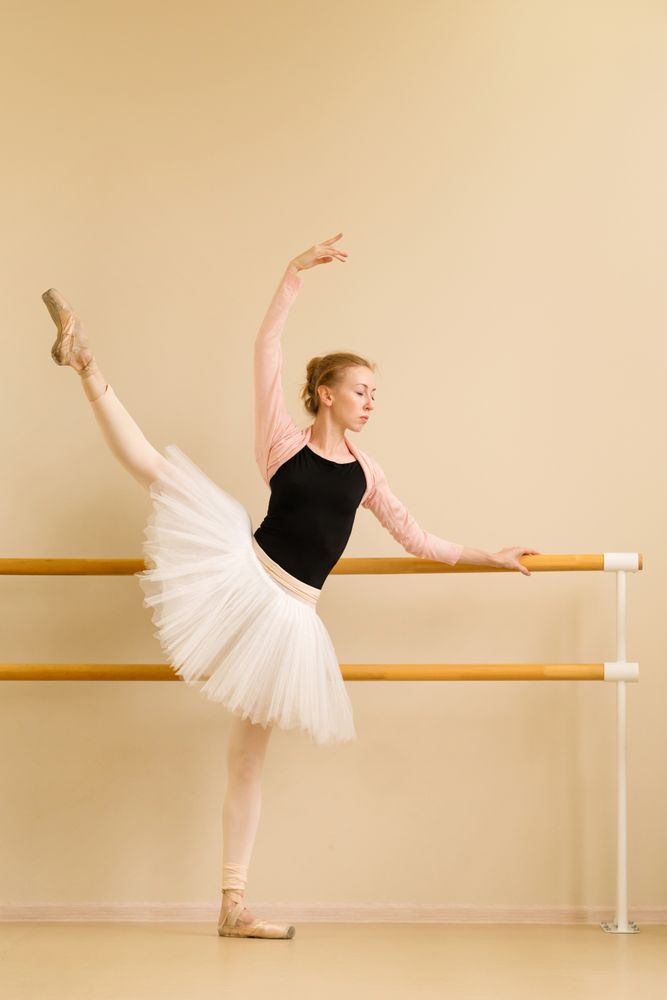 Ballet dancer practicing leg lift with graceful arm pose