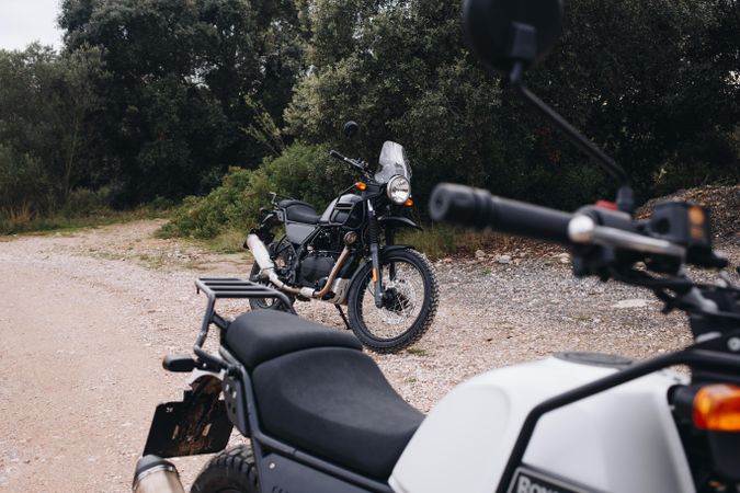 Two motorcycle bikes parked on dirt road